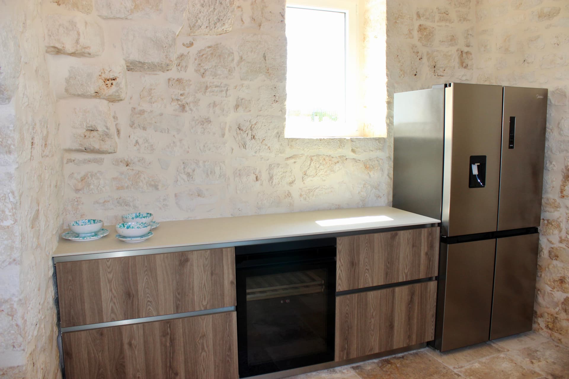 Cucina con parete in pietra a vista