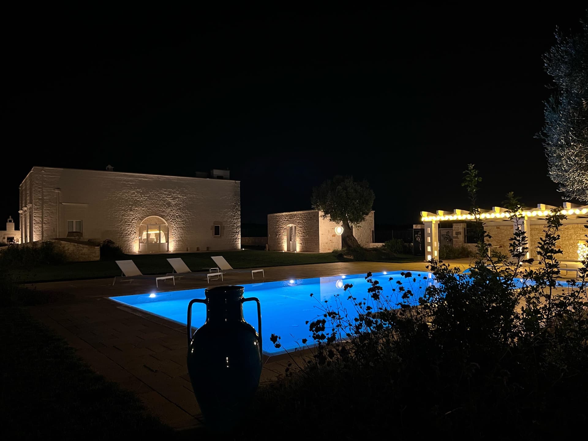 Piscina illuminata di notte con anfora