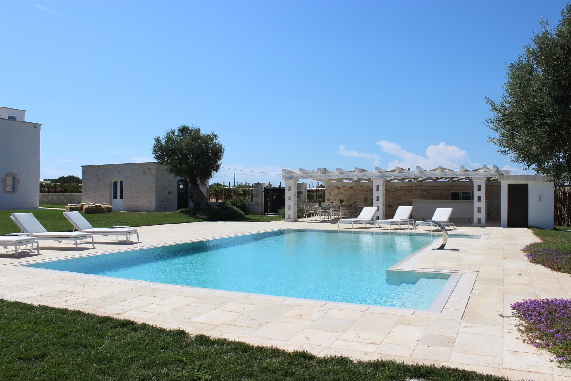 Piscina con pergola e lettini